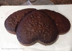 three chocolate cookies sitting on top of a piece of paper