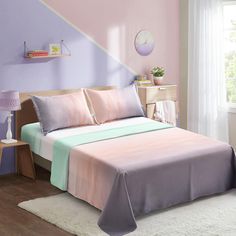 a bed with pink and purple sheets on top of it in a bedroom next to a window