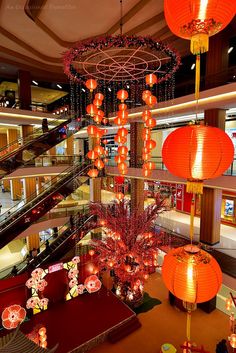 the interior of a shopping mall with red lanterns hanging from the ceiling and chandeliers