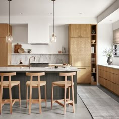 an image of a kitchen setting with bar stools and island in the middle,