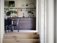 an open kitchen and dining room area with wooden steps leading up to the living room