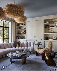 a living room filled with furniture next to a window covered in lots of bookshelves