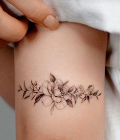 a woman's arm with a flower tattoo on it