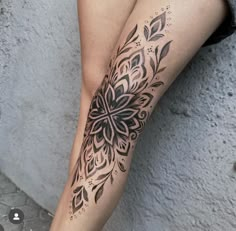 a woman's leg with a flower tattoo on her left calf and the bottom half of her leg