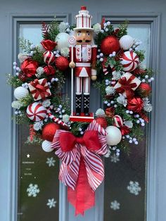 a christmas wreath with a nutcracker figure hanging from it's front door