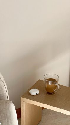 a cup of coffee sitting on top of a wooden table next to a computer mouse