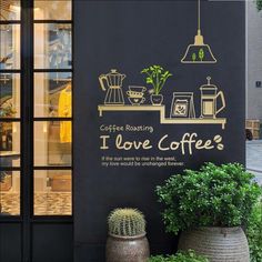 coffee roasting i love coffee wall decal on the outside of a building with potted plants