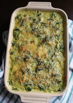 a casserole dish with broccoli, carrots and cheese in it