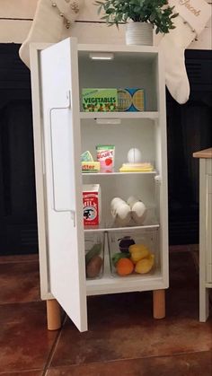 a white refrigerator freezer sitting inside of a kitchen next to a potted plant