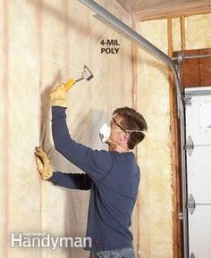 a man is working on the wall in his home under construction with gloves and work gloves