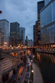 the city skyline is lit up at night with lights reflecting in the water and skyscrapers