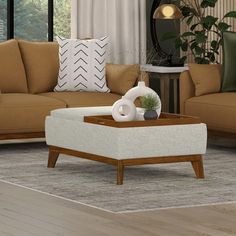 a living room filled with furniture and pillows on top of a wooden coffee table in front of a window