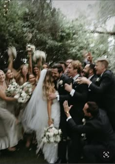 a bride and groom are surrounded by their wedding party