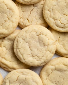 a pile of cookies sitting on top of a white tablecloth next to each other