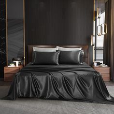 a bed with black sheets and pillows in a dark room next to a large window