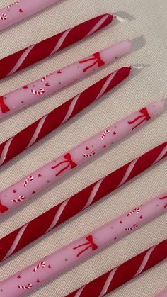 six pink and red candy canes are lined up