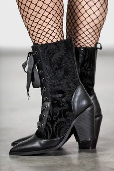 a close up of a person's legs wearing black boots and fishnet stockings