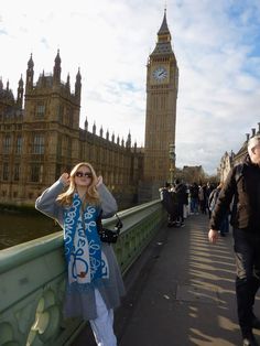 a woman standing on a bridge in front of big ben