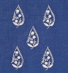 four white embroidered drops on blue fabric with flowers and leaves in the center, set against a dark blue background