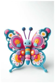 a crocheted butterfly sitting on top of a white surface