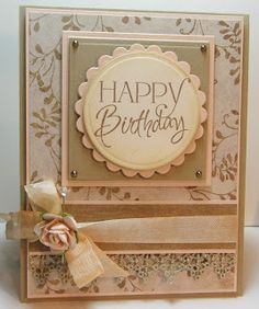 a happy birthday card with flowers and ribbons on the front, sitting on a table