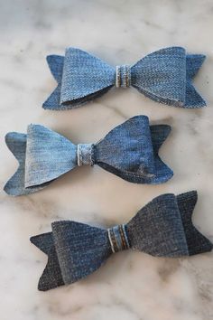 three denim bow ties sitting on top of a marble counter