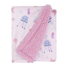 a pink blanket with an octopus and jellyfish design on it, sitting next to a pillow