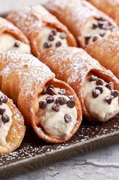 several pastries with chocolate chips and powdered sugar on a metal platter, ready to be eaten