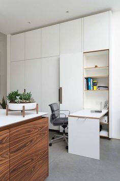 an office with white walls and wooden furniture in the center, along with bookshelves