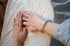 two hands touching each other with rings on their fingers