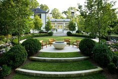 an outdoor garden with steps leading up to the front door and seating area on either side