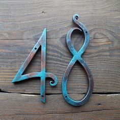 the number four is made out of metal and sits on a wooden surface with an iron hook