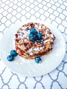 blueberry waffles with powdered sugar on a white plate