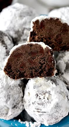 some chocolate and white desserts are in a blue bowl with powdered sugar on top