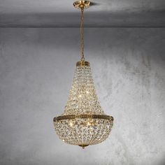 a chandelier hanging from the ceiling in a room with concrete walls and flooring