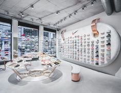 the inside of a shoe store with lots of shoes on display in front of large windows