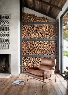 a living room with wood stacked on the wall and a chair in front of it