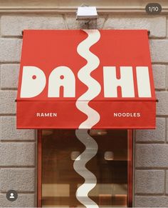 a red awning on the side of a building with white letters that read, dash ramen noodles