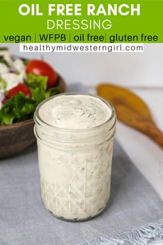 a mason jar filled with ranch dressing next to a salad