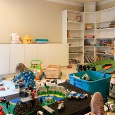 a child playing with toys in a playroom filled with furniture and bookshelves