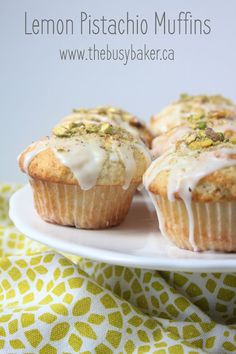 lemon pistachio muffins on a white plate with yellow and green fabric