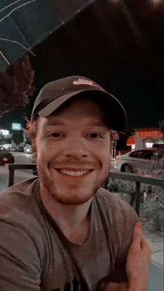 a man with a baseball cap smiling at the camera