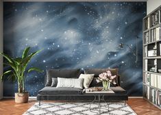 a space themed living room with bookshelves, couch and coffee table in front of the wall