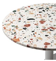 a white table with multicolored rocks on it's top and metal legs