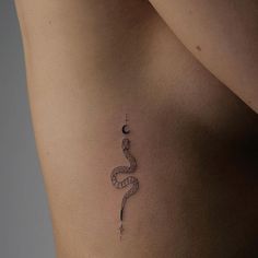 a woman's stomach with a snake tattoo on her left side ribcage