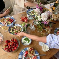 several people sitting at a table with plates of food