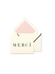 two envelopes with the word merci printed on them, one pink and one white