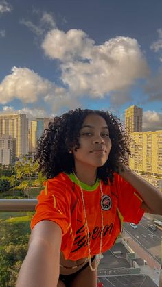 a woman in an orange shirt is posing for the camera