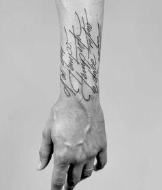 a person's hand with a tattoo on it and the words in cursive writing