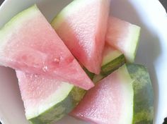 four slices of watermelon in a white bowl